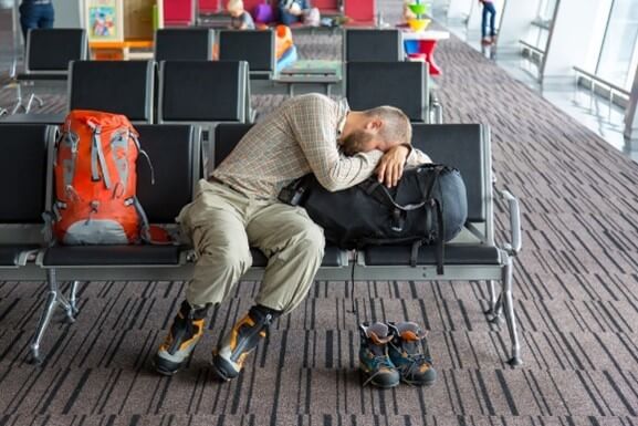 Guy sleeping at airport.