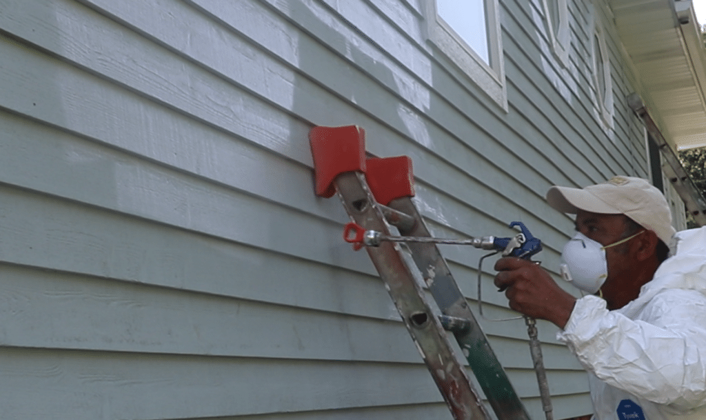 HOME SERVICE INDUSTRY IS BOOMING SHOWING A MAN PAINTING SIDING