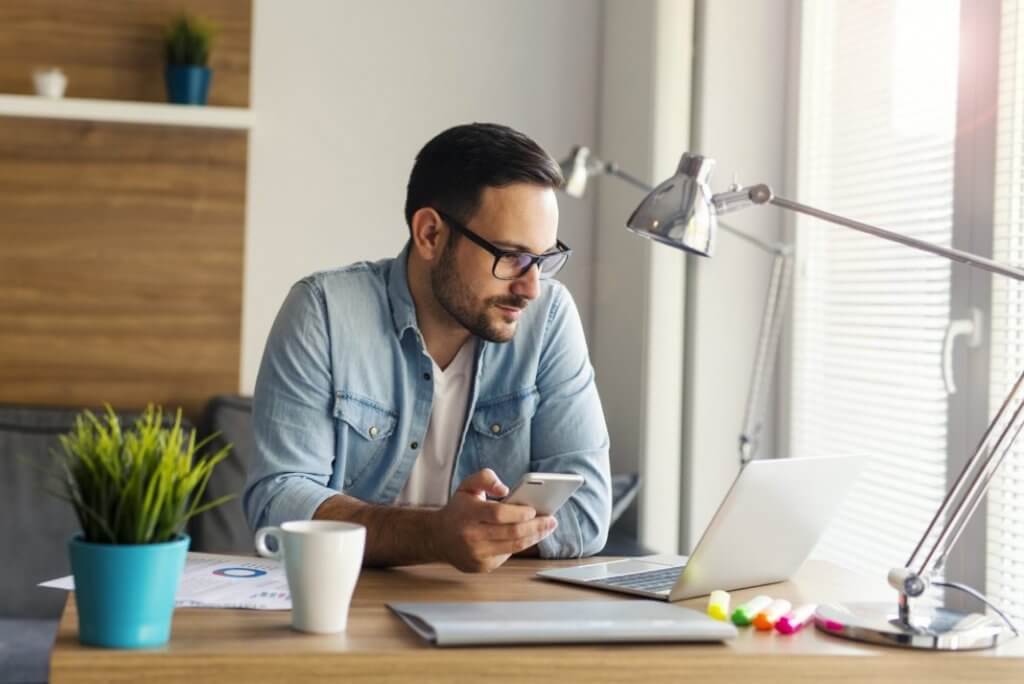 Man on computer adding up franchise start-up costs
